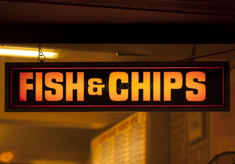 Fish and chip shop neon sign. At night stock photography